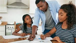 dad helping daughters with homework 